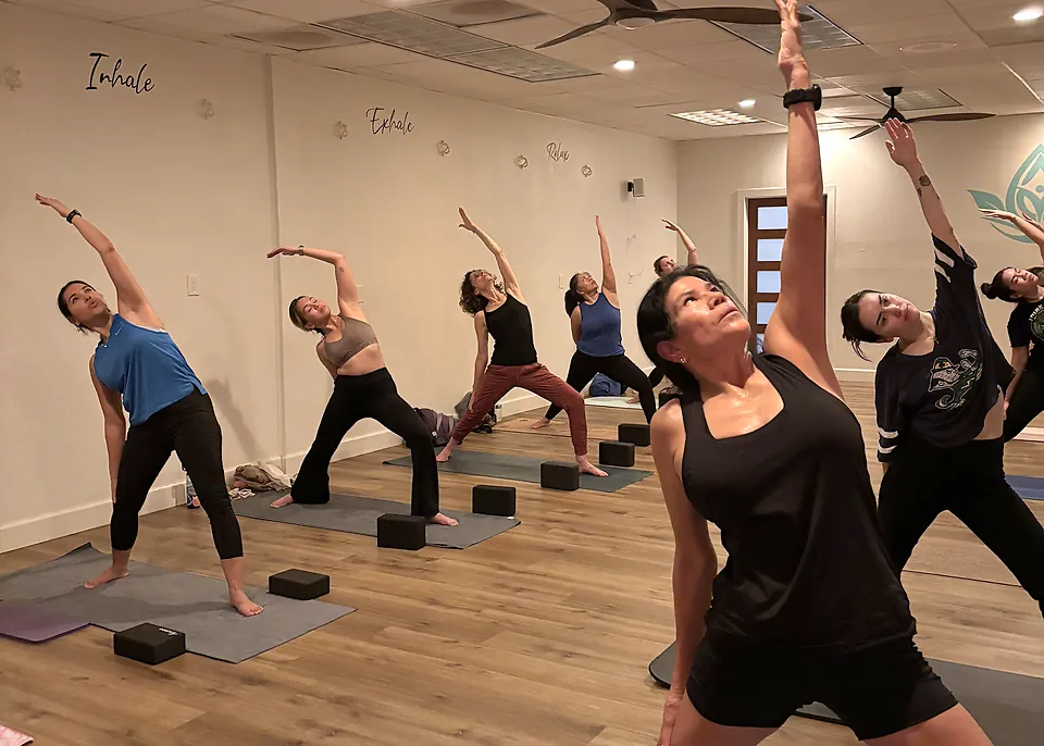 Honey Flow Hot class reaching into a side stretch at Serenity Hot Yoga