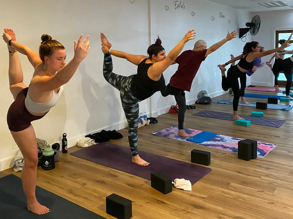 Morning Flow class balancing in dancer pose at Serenity Hot Yoga