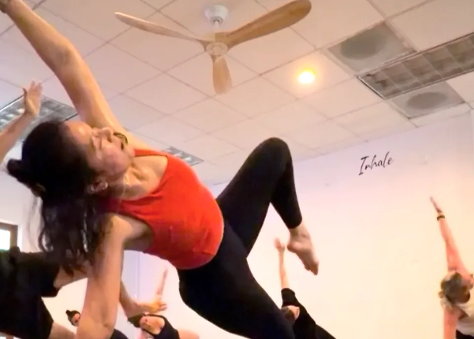 Pilates Fusion student in a side plank on a block at Serenity Hot Yoga