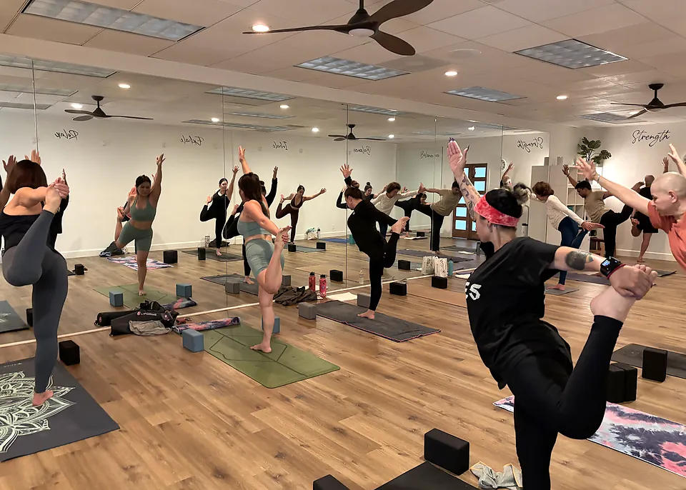 Serenity Sequence class balancing in standing bow pose at Serenity Hot Yoga