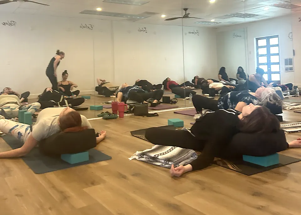 Students resting on bolsters during a Vin Yin Hot class at Serenity Hot Yoga