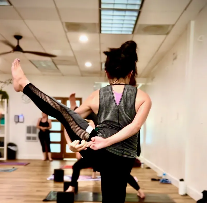 Student in bird of paradise pose during a heated class at Serenity Hot Yoga