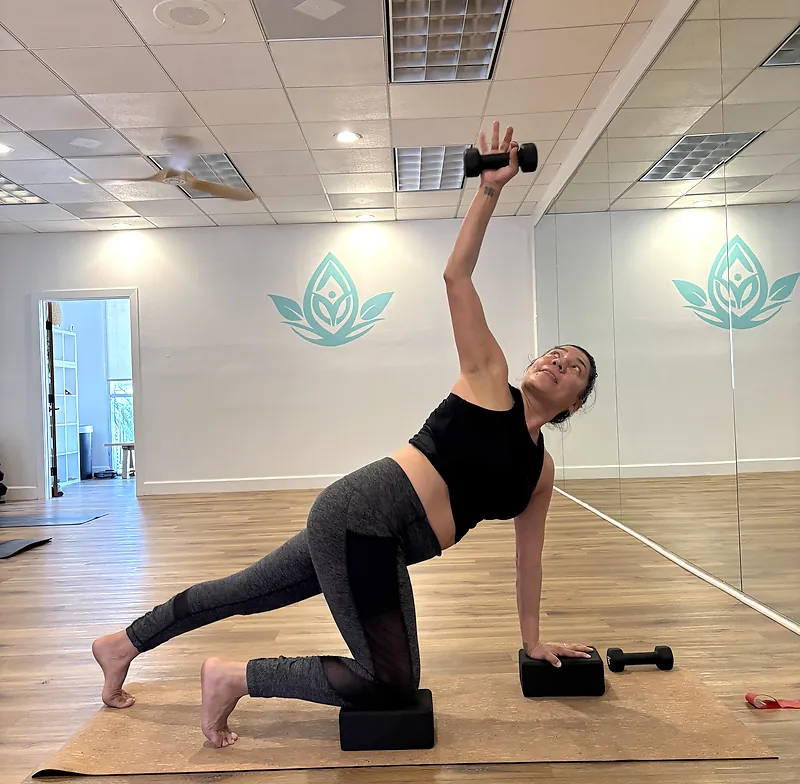 Student lifting a dumbbell during a Yoga Sculpt class at Serenity Hot Yoga